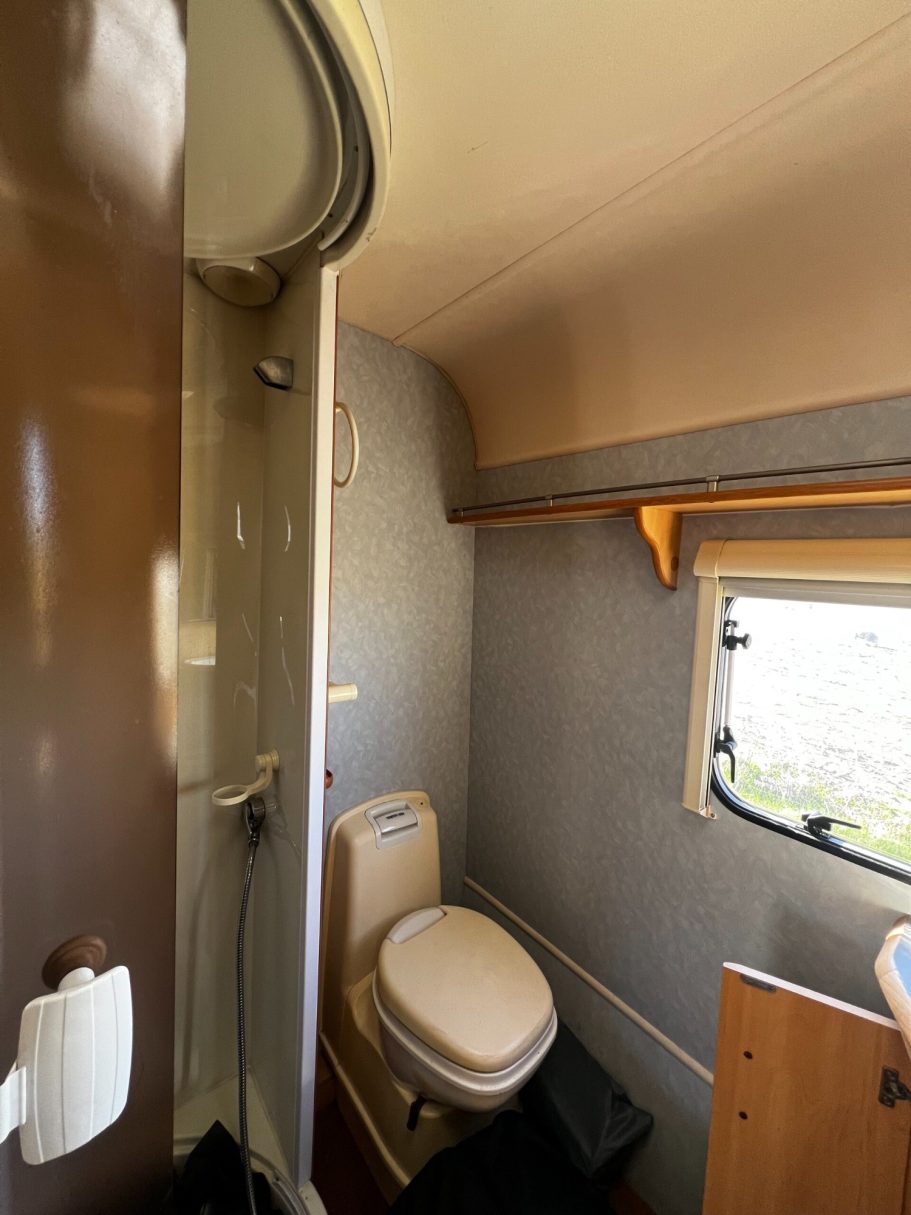 Compact bathroom with a shower and toilet in a small space.