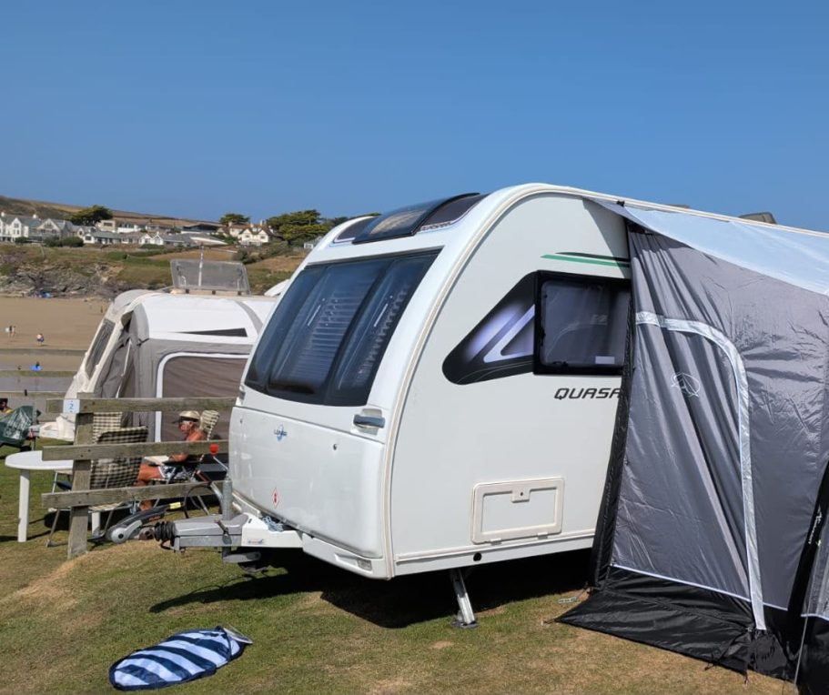 SquaredAway rental caravan with awning set up on a seaside campsite.